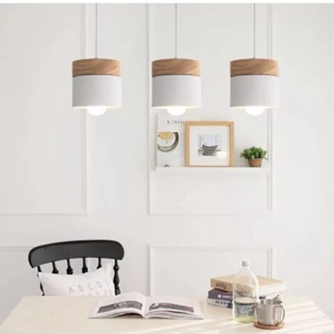 Suspension scandinave en bois présentée 3 fois installée au dessus d'une table à manger