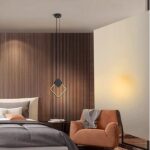 Lampada a sospensione a led nera a forma di rombo accanto a una parete in listelli