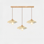 Lampadario à trois suspensions, un socle rectangulaire en bois et les suspensions en verre en forme de fleur. Sur un fond blanc.
