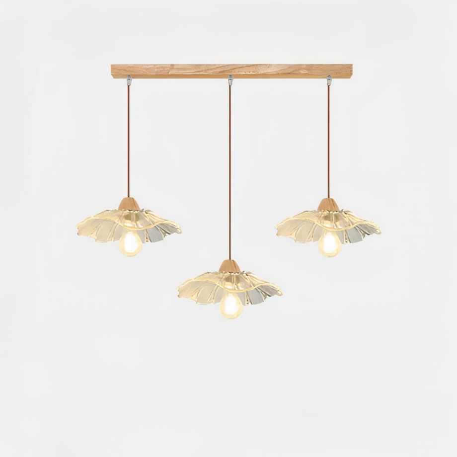 Lampadario à trois suspensions, un socle rectangulaire en bois et les suspensions en verre en forme de fleur. Sur un fond blanc.