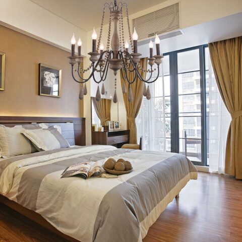 Lampadario chambre adulte rétro en bois massif sur fond beige dans une chambre avec un lit