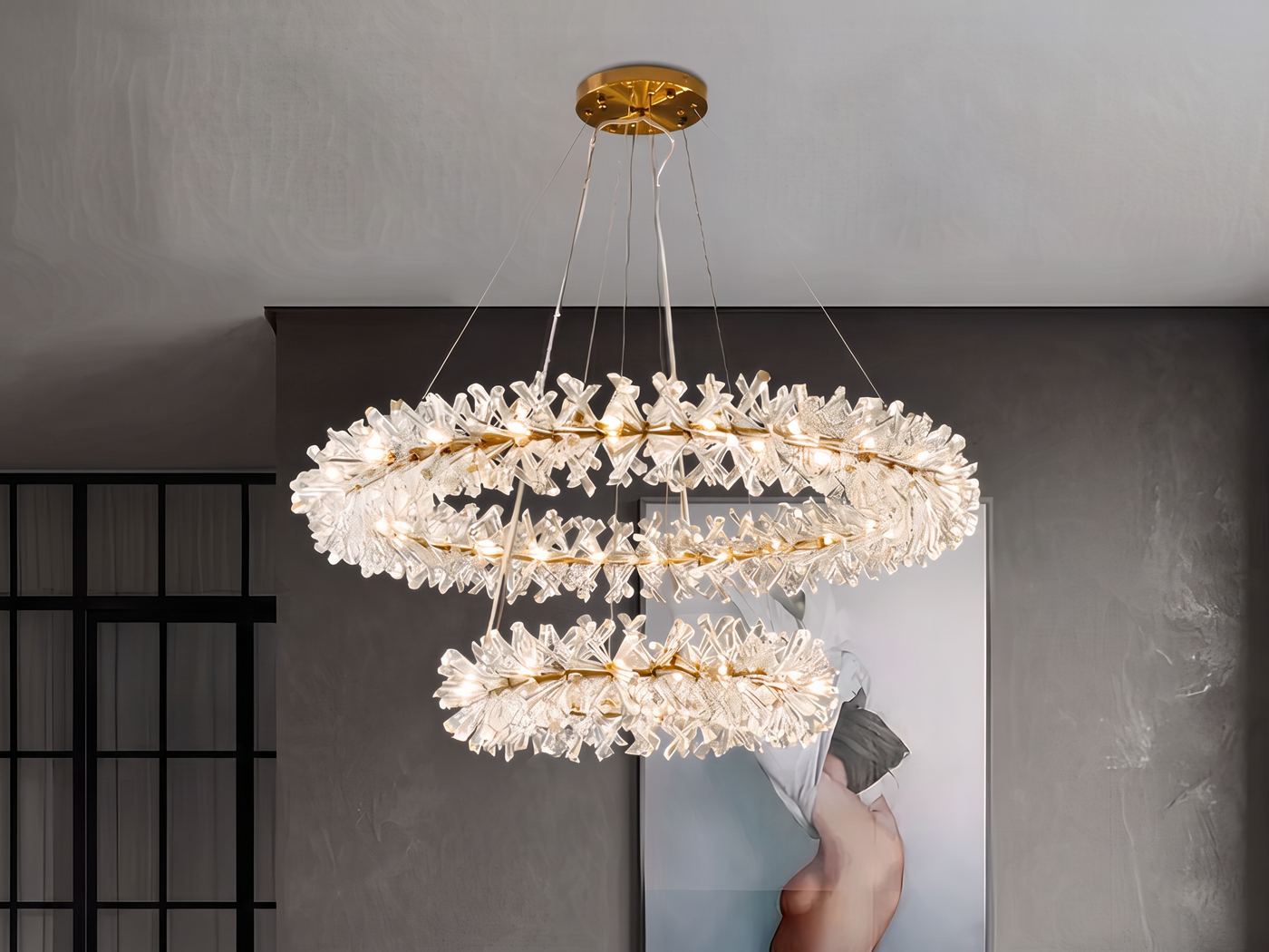 Lampadario a corona di cristallo a due livelli, acceso sopra una cassettiera con specchio