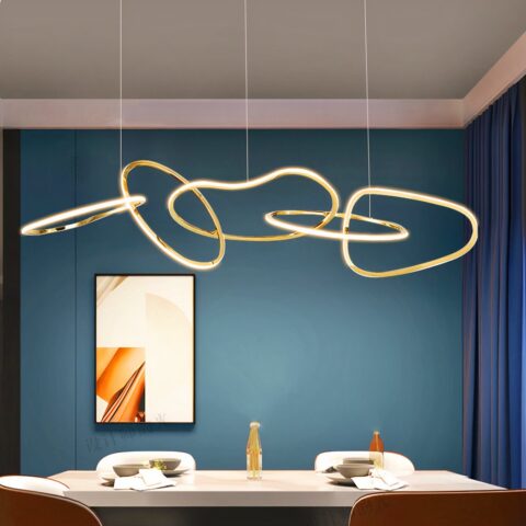 Lampadario salle à manger moderne avec anneaux lumineux sur fond bleu avec une table