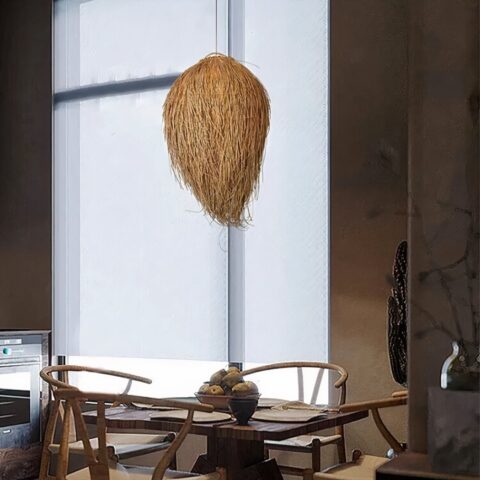 Lampadario en rotin, en forme de boule recouvert de fils qui tombent. Au-dessus d'une table carrée en bois avec 4 chaises en bois. Derrière, on voit une grande fenêtre du sol au plafond.