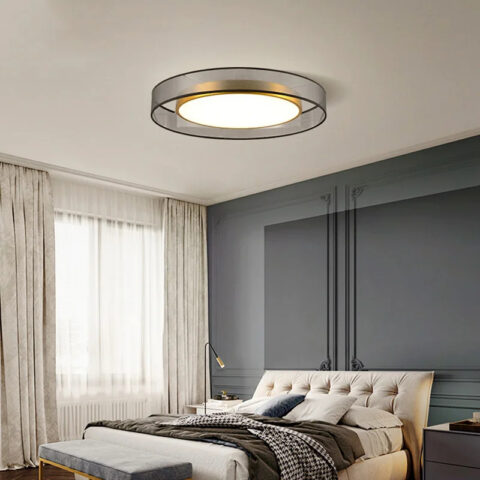 Lampadario chambre adulte style années 70 en tissu et métal doré accroché au plafond d'une chambre et allumé.