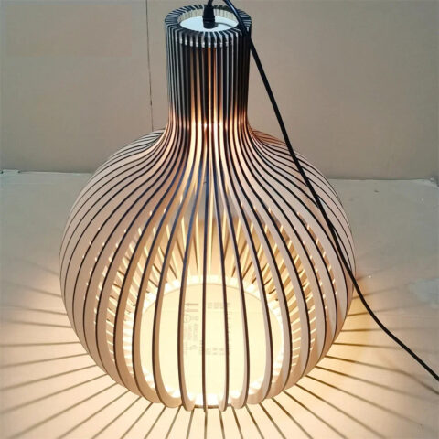 Lampadario DIY en bois massif de bambou, assemblé et allumé, sur fond beige.