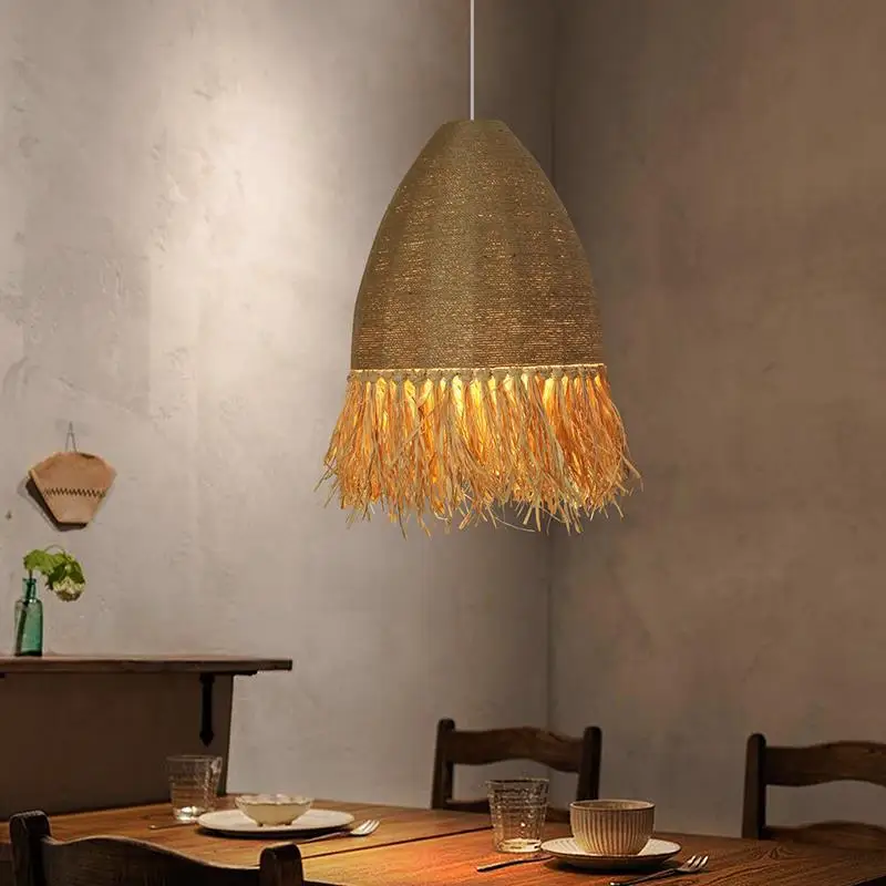 Img_03_2024_lustre_paille_et_corde_fait_à_la_main_11 Lampadario en paille et corde fait à la main suspendu et allumé au-dessus d'une table de salle à manger dressée pour le repas.