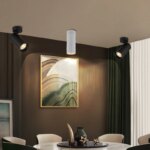 Applique spot plafond LED noire salon moderne, installée sur un plafond de salle à manger avec une version blanche.