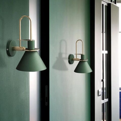 on voit un mur vert fondé et dessus deux appliques murales posées de couleur verte foncés dans le style scandinave