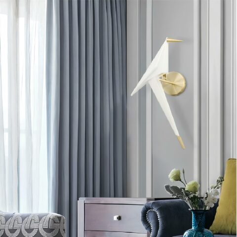 on voit dans un salon aux tons gris une applique murale en origami et en forme d'oiseau blanche et dorée