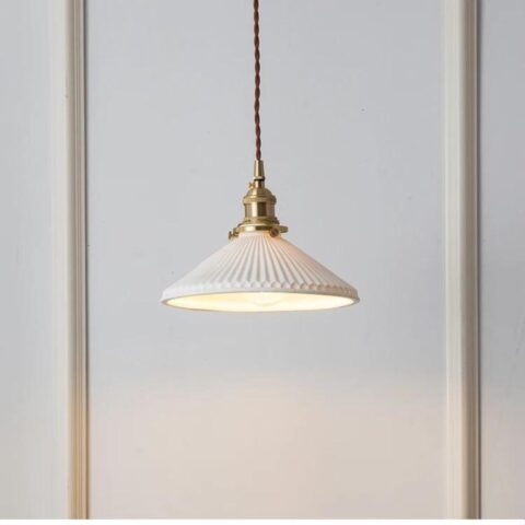 on voit sur un fond blanc une suspension en céramique blanche et en cuivre dans le style vintage