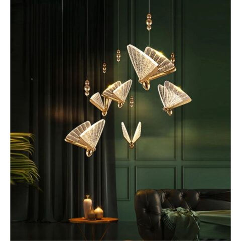 on voit dans un salon aux tons foncés marron vert une suspension dorée et transparente en forme de papillon