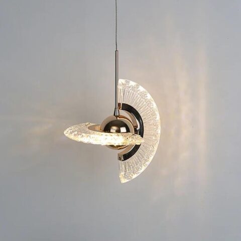 on voit sur un fond gris clair une suspension en forme de planète rotative dorée et transparente