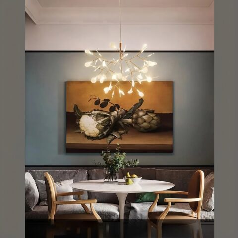 Lampadario suspension moderne à LED original en forme d'arbre doré suspendu et allumé au-dessus d'une table de salle à manger.
