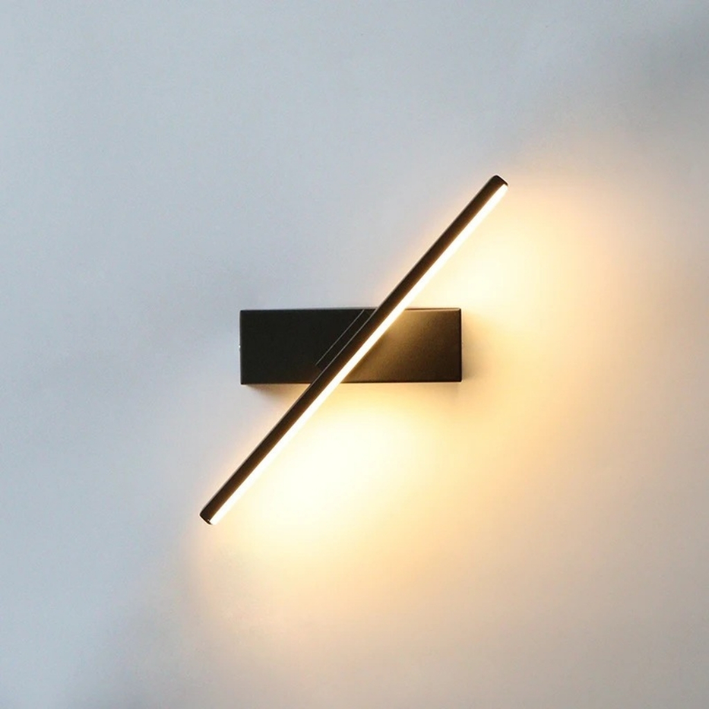 Applique LED nera con barra luminosa orientabile su parete bianca